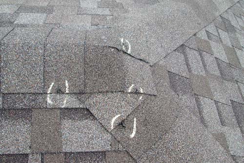 Hail damaged roof with circled divets